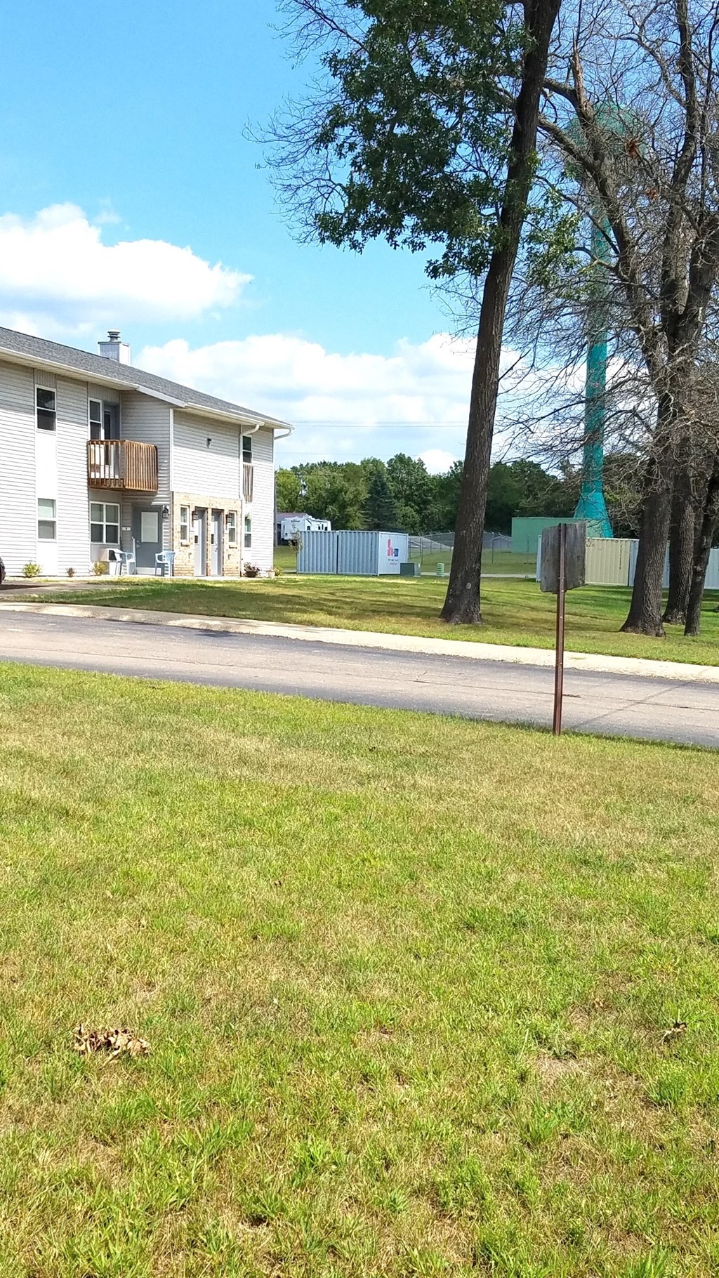 a house on the side of a road next to a grass field