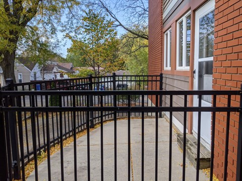 A black metal fence surrounds a brick building.