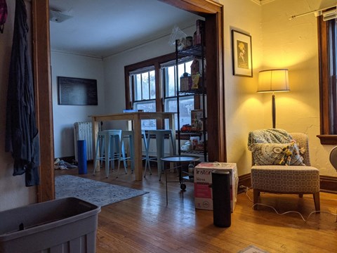 A room with a chair and a table in it.