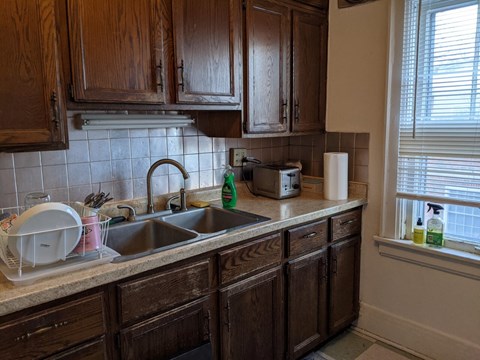 A kitchen with wooden cabinets and a white sink.