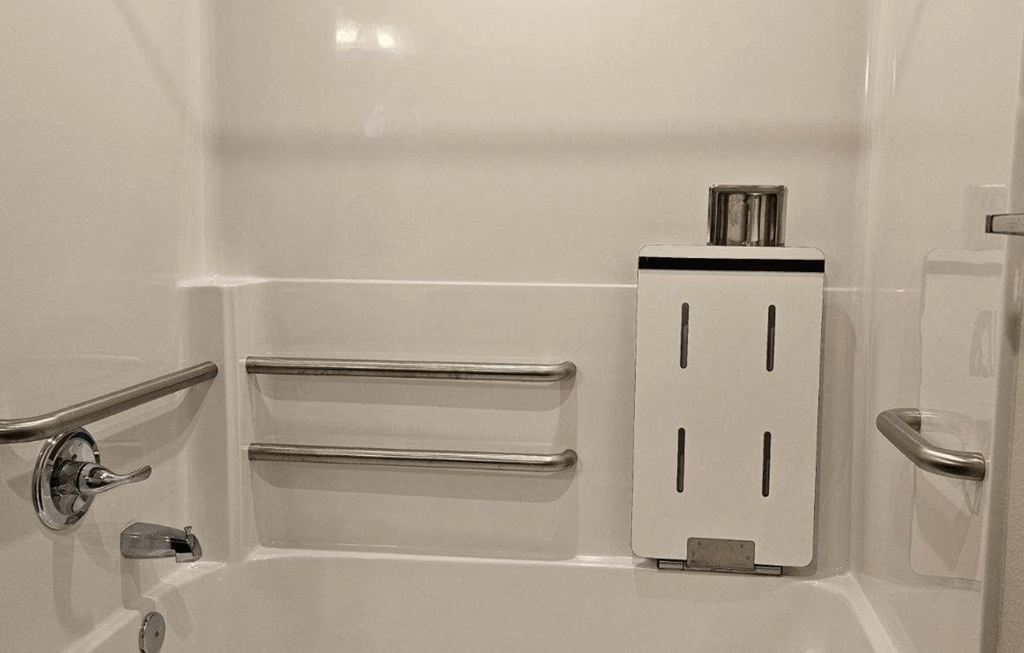 a small bathroom with a sink and a soap dispenser