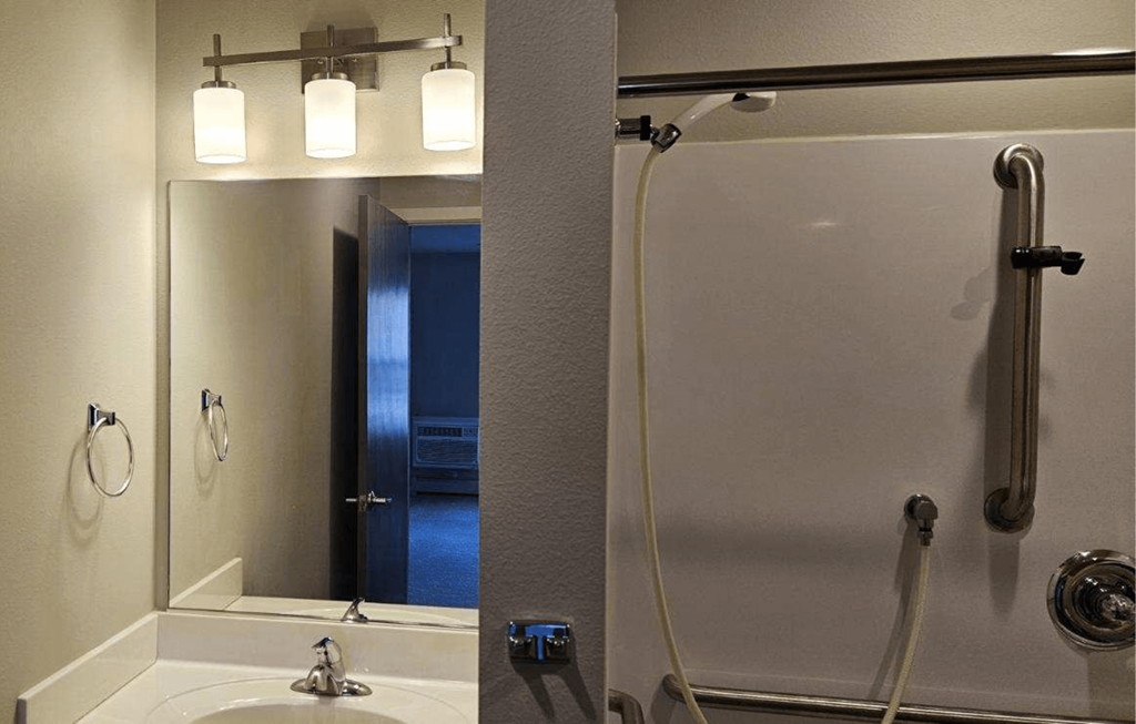 a bathroom with a shower and a sink and a mirror