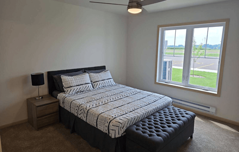 a bedroom with a bed and a large window