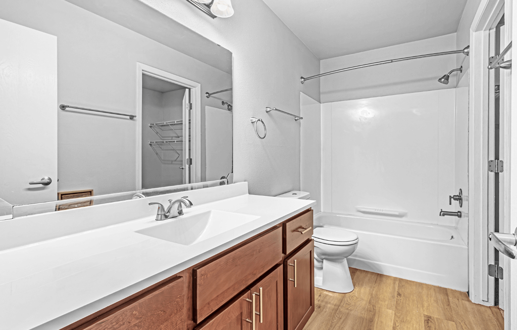 A white bathroom with a white sink and toilet.