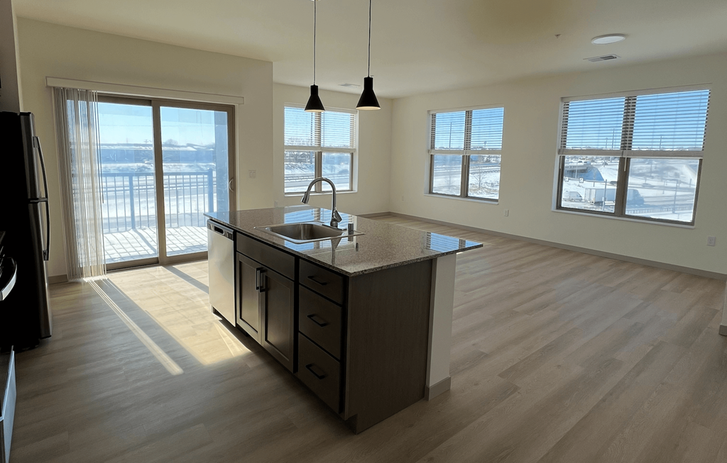A kitchen with a wooden floor and a large island in the middle.
