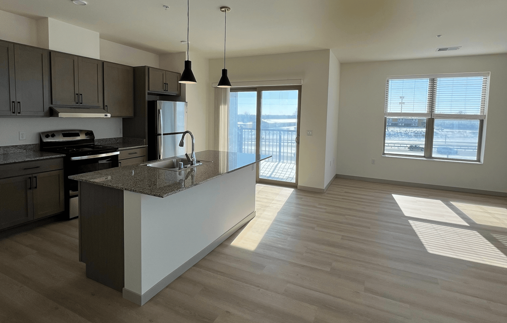A kitchen with a marble countertop and a refrigerator.