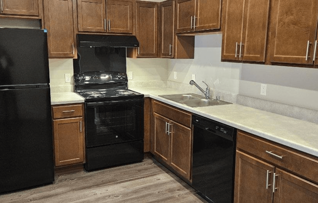 a kitchen with black appliances and wooden cabinets