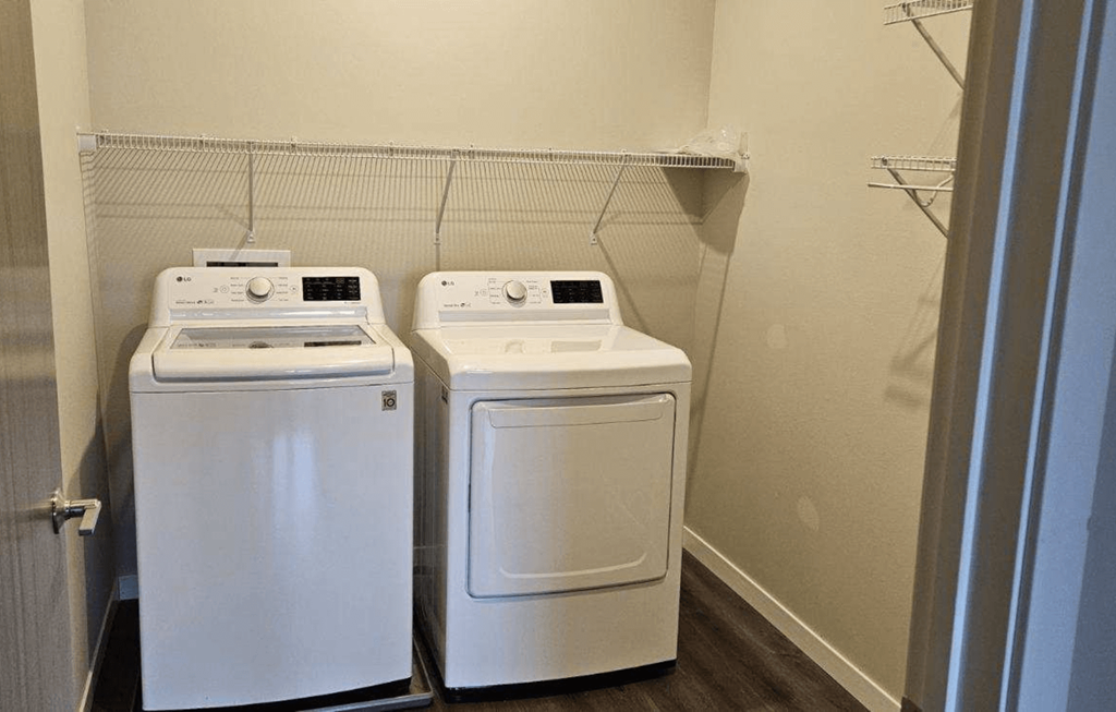 two washers and dryers in a room with a door