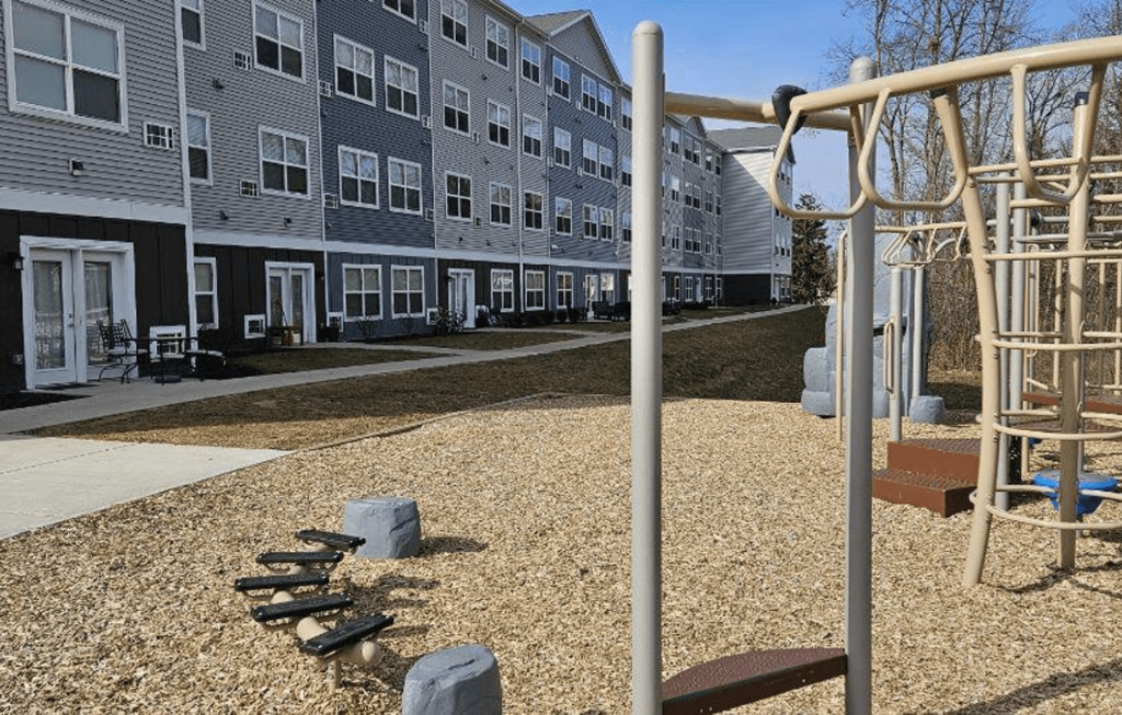 an empty playground in front of an apartment building