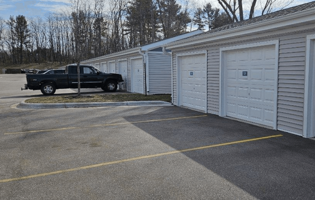 a black truck parked in front of a garage