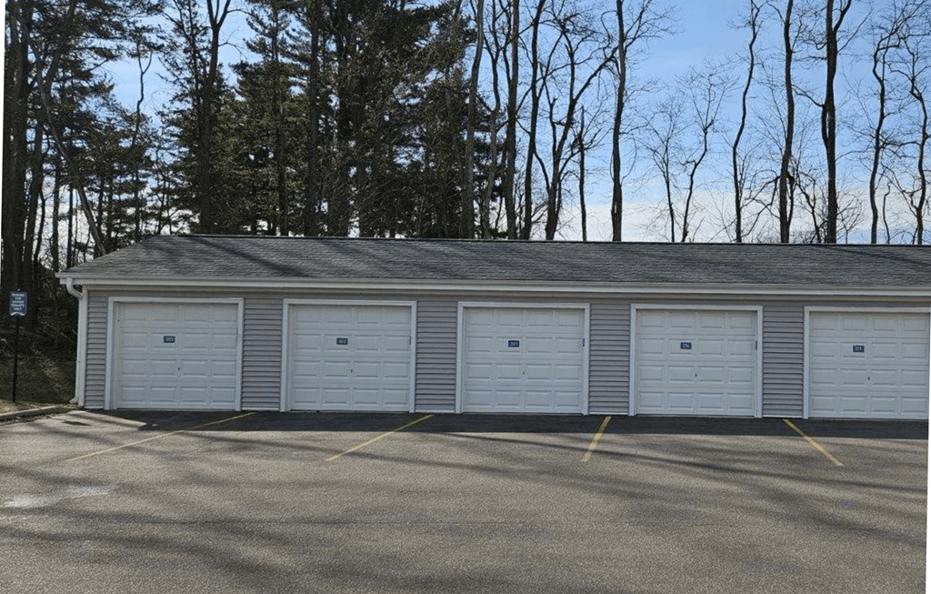 a row of white garage doors in a parking lot