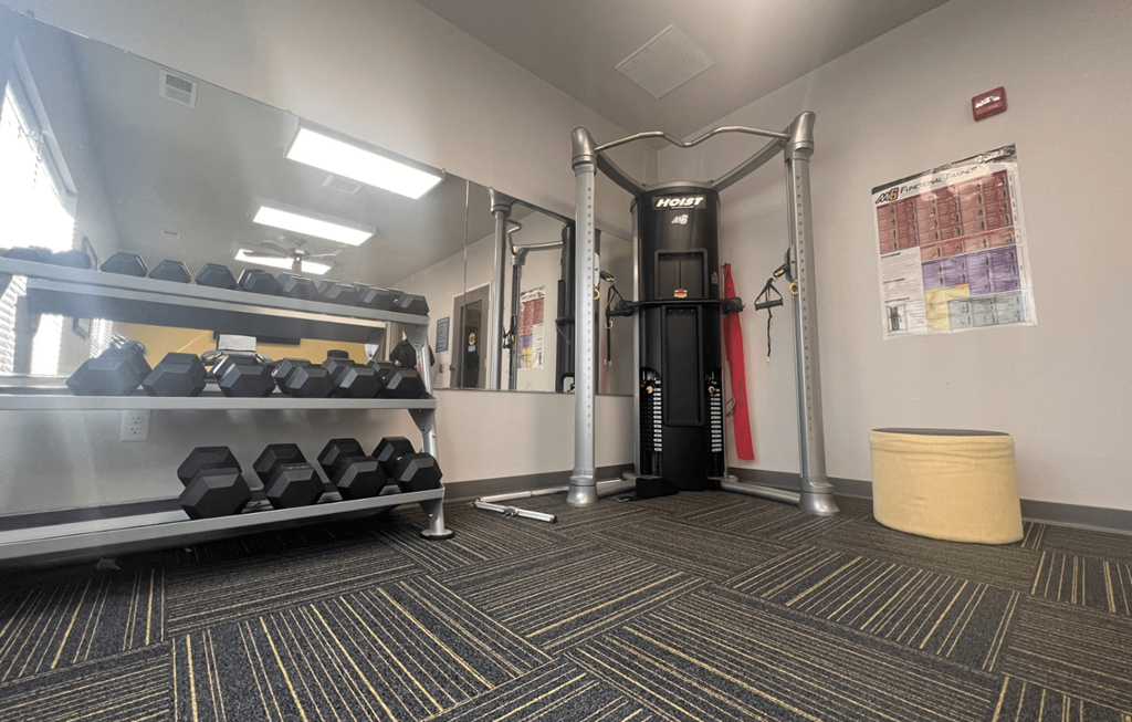 a gym with treadmills and weights in the corner of a room