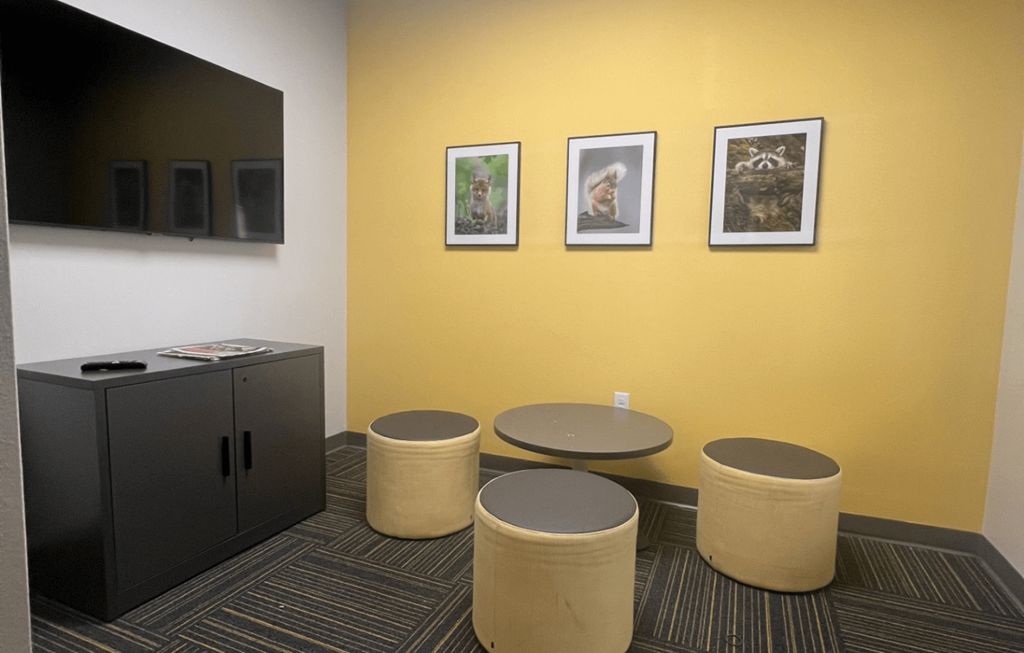 a room with four stools and a table and a tv