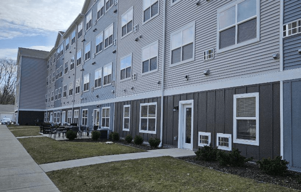 the exterior of an apartment building with a sidewalk