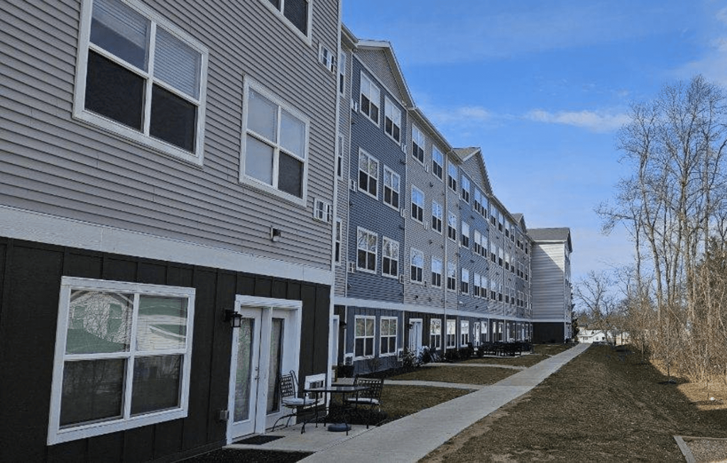 a row of houses with a sidewalk in front of them
