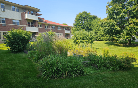 A grassy area in front of a building with a red roof.