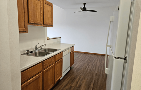 A kitchen with wooden cabinets and a white fridge.