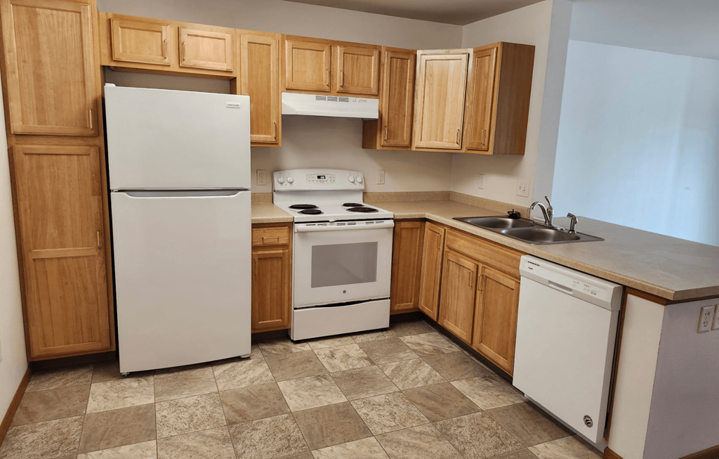 A kitchen with a white refrigerator, white oven, and white dishwasher.
