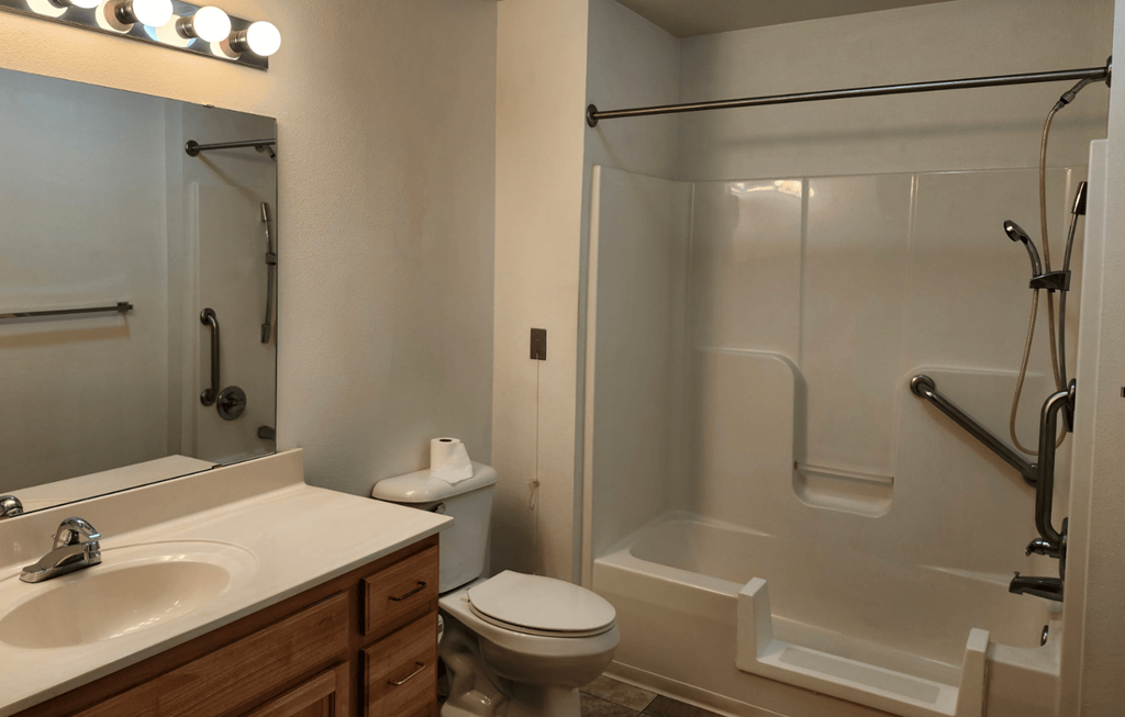 A bathroom with a toilet, sink, and shower.