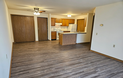 A kitchen area with wooden cabinets and a refrigerator.