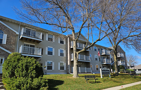 A large grey apartment building with a balcony on the second floor.