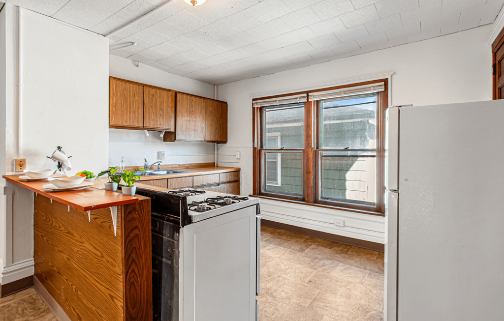 A kitchen with white cabinets and a window.