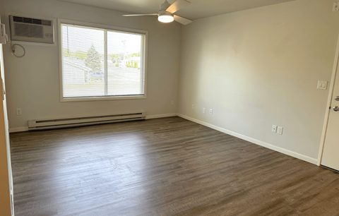 A room with a window and a ceiling fan.