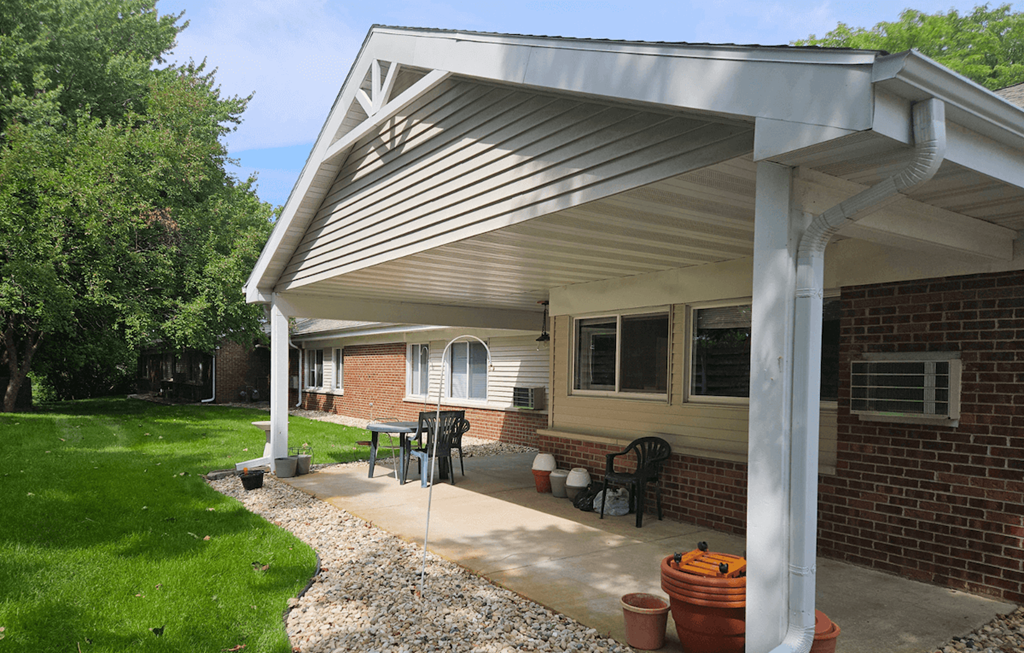 a patio with a pergola in front of a brick building