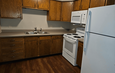 a kitchen with white appliances and wooden cabinets