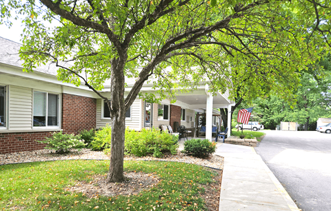 a building with a tree in front of it and a sidewalk