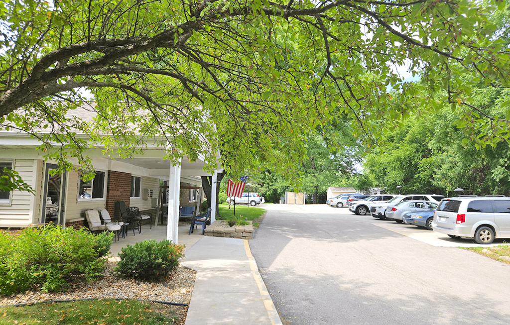 a street with a house and cars parked on the side of the road