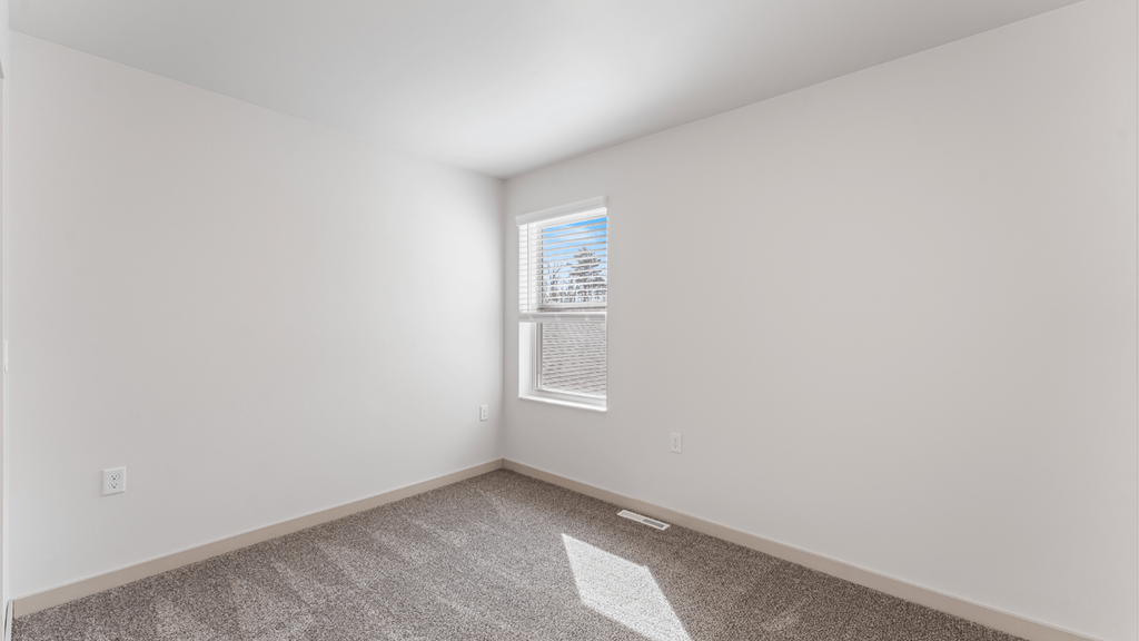 A room with a window and carpeted floor.