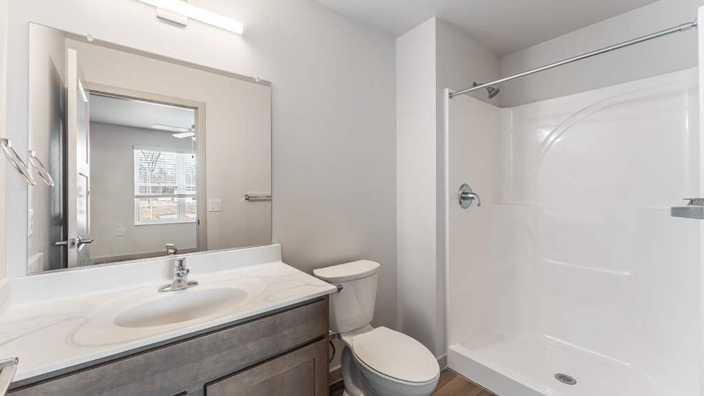 A bathroom with a toilet, sink, and shower.