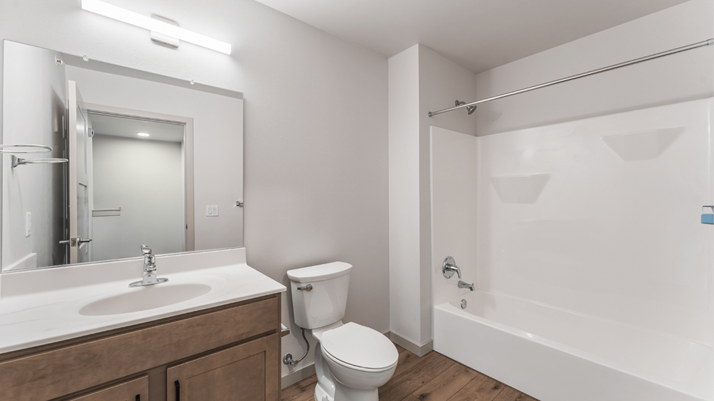 A white bathroom with a toilet, sink, and bathtub.