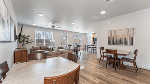 A spacious living room with a large wooden table and chairs.