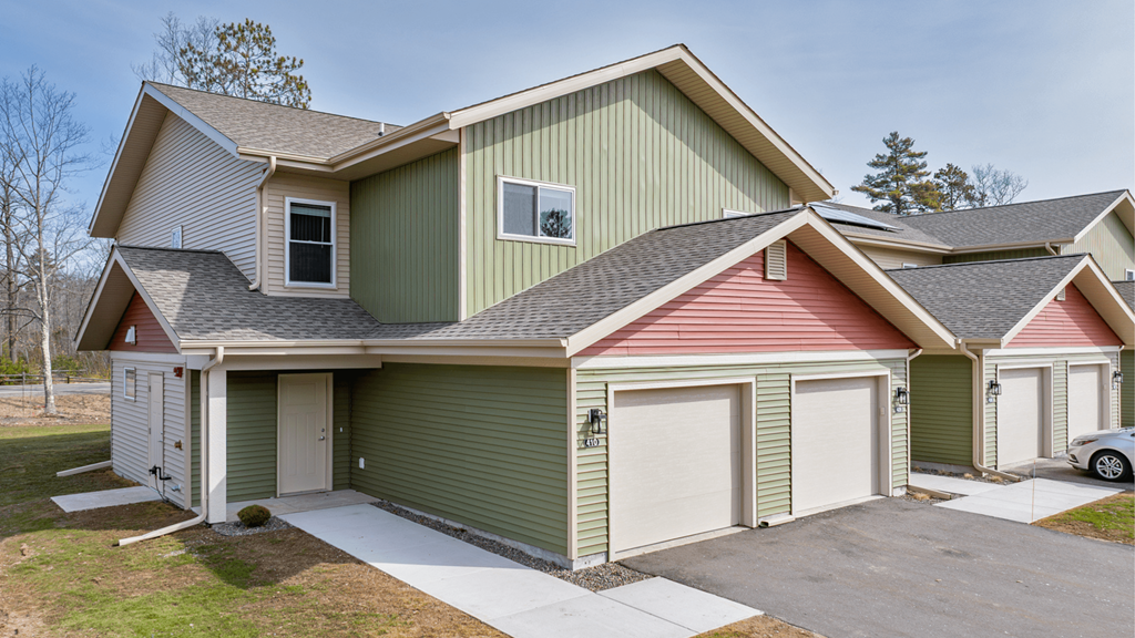 A house with a green and red roof and a white garage door.