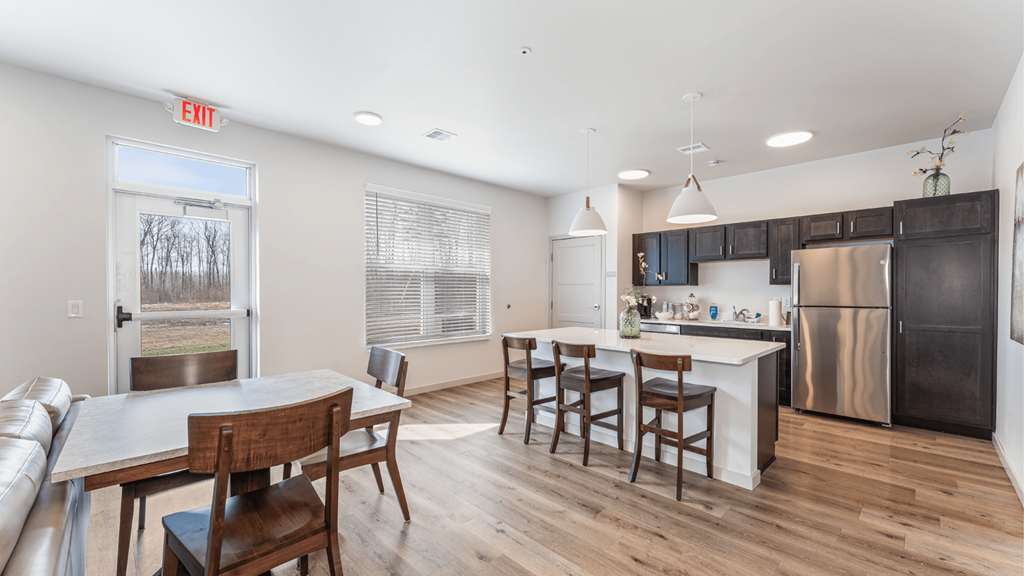A kitchen with a table and chairs in the middle of the room.