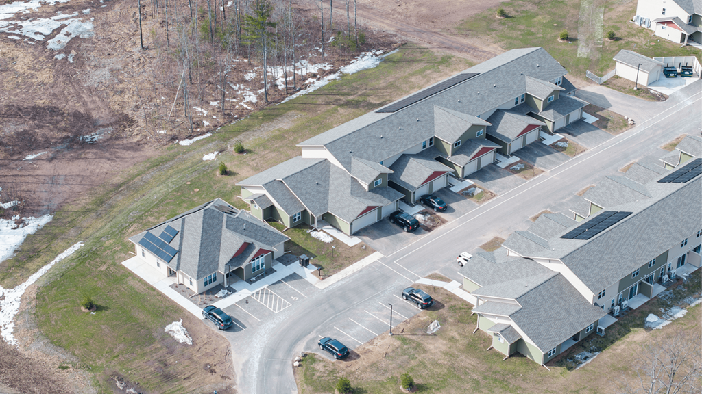 A large building complex with a parking lot in front.