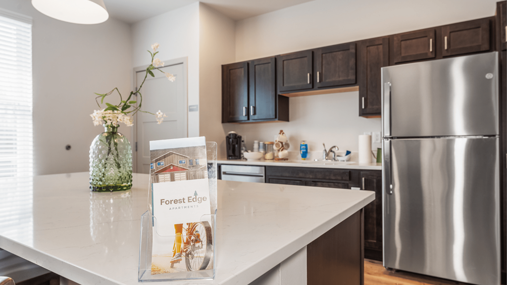 A kitchen with a white countertop and a sign that says "Forest Edge".