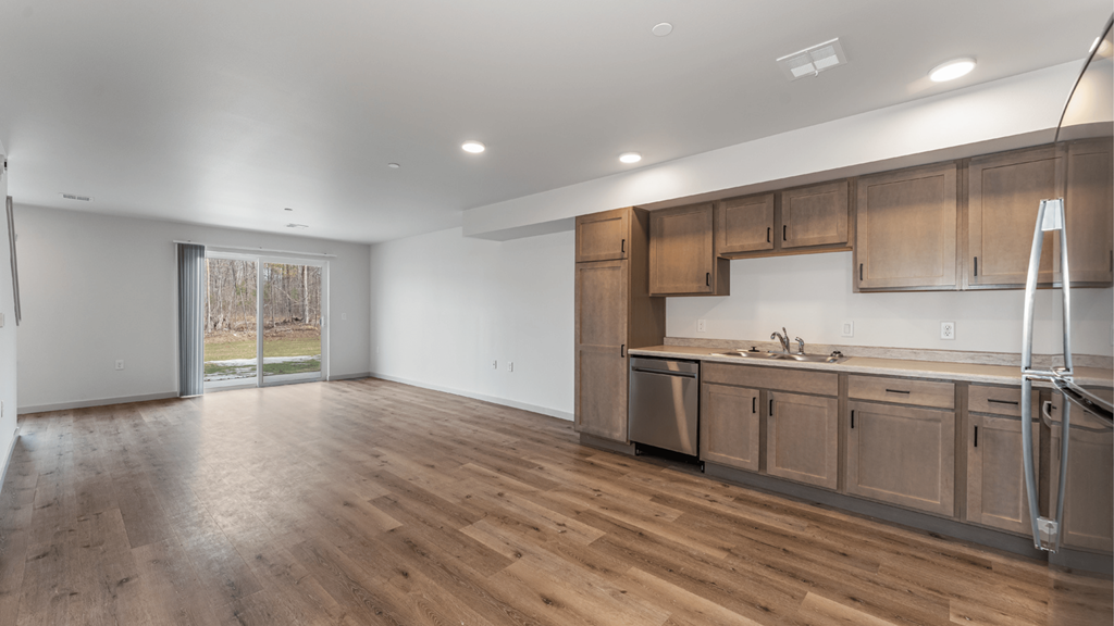 A kitchen with wooden floors and a white ceiling.
