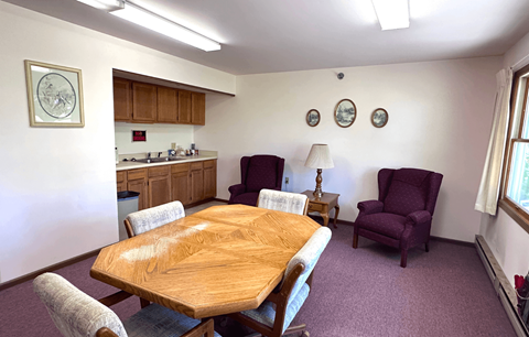 A dining room with a wooden table and chairs.