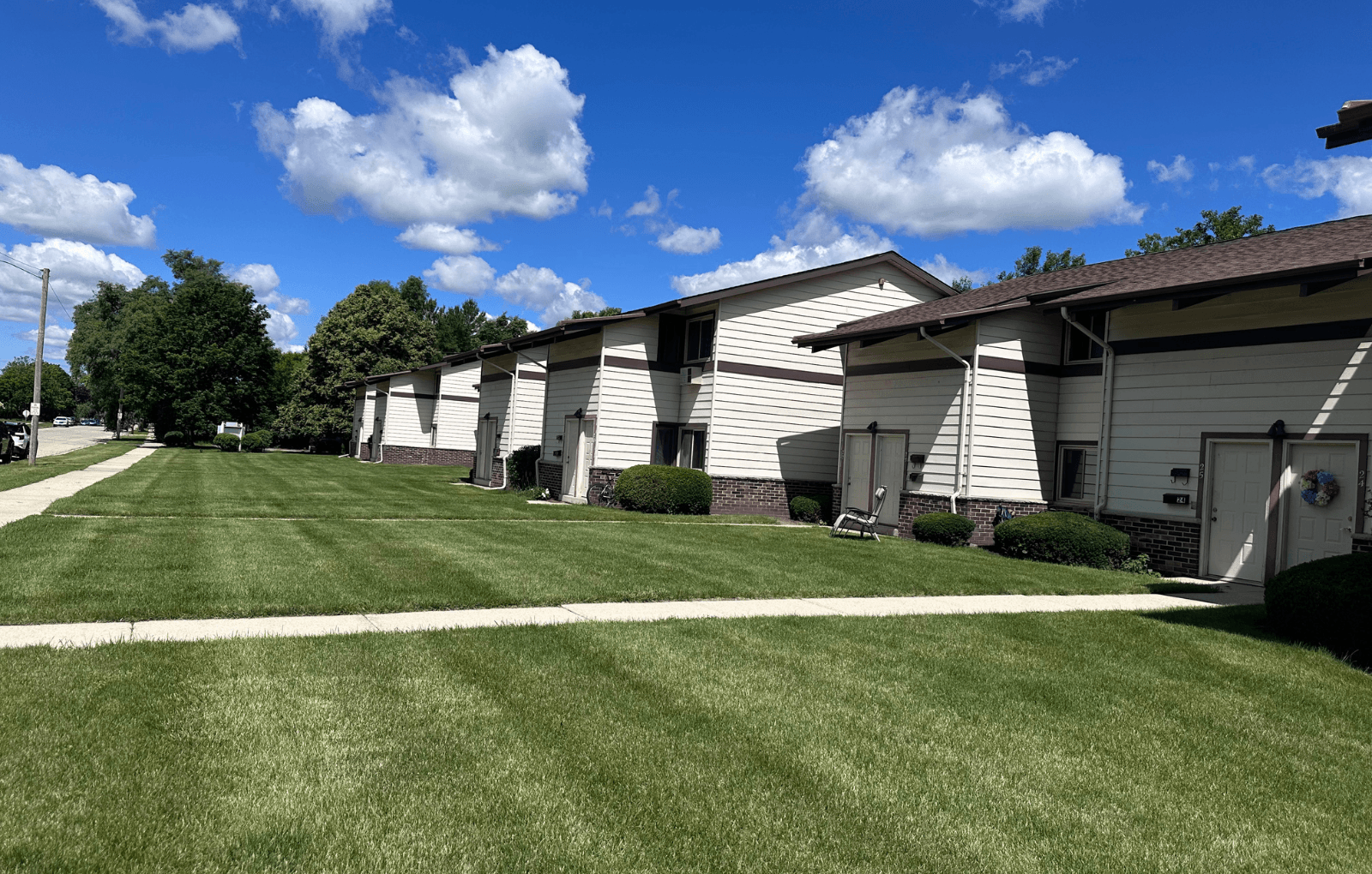 A row of houses with a blue sky and clouds above.