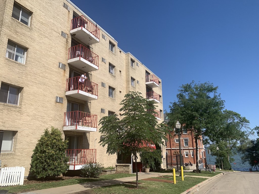 a large brick apartment building with balconies and trees
