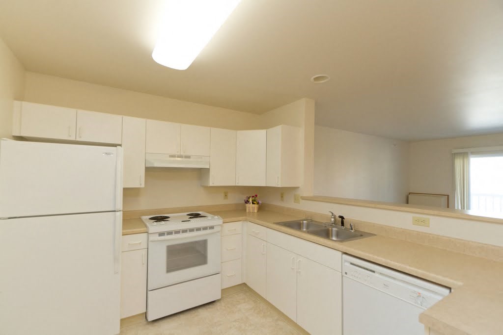 a kitchen with white appliances and white cabinets