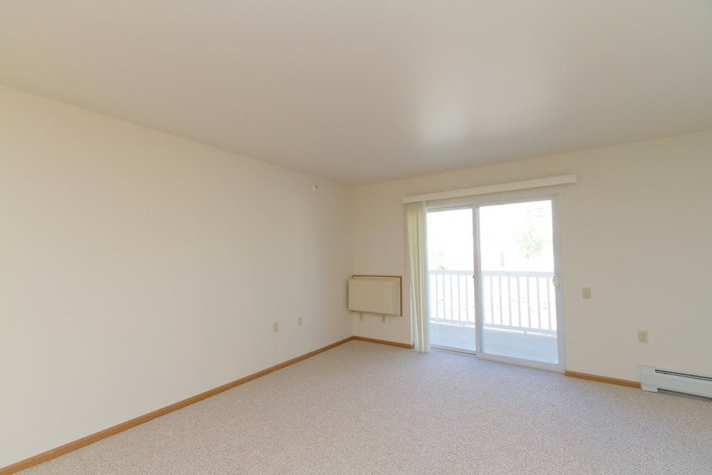 the living room of an empty apartment with a sliding glass door