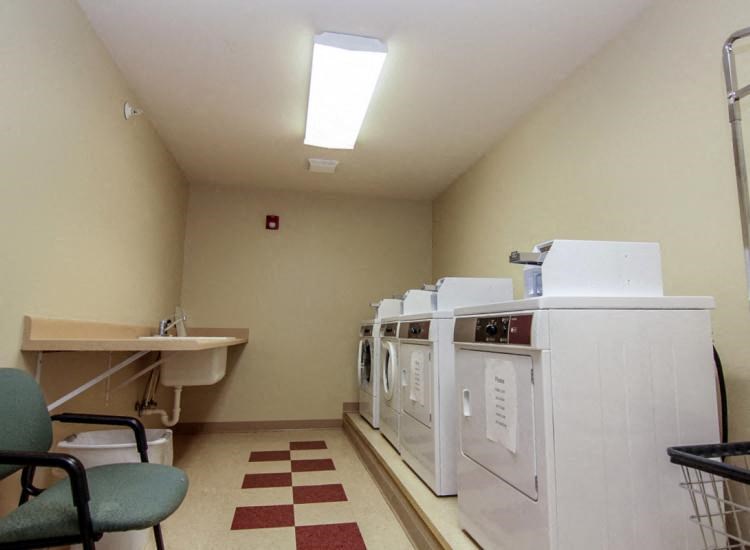 a laundry room with two washing machines and a sink