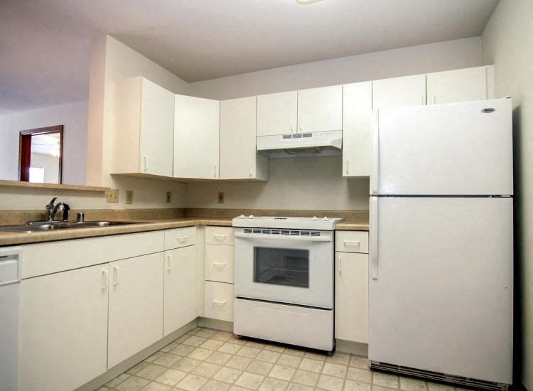 a white kitchen with white appliances and white cabinets