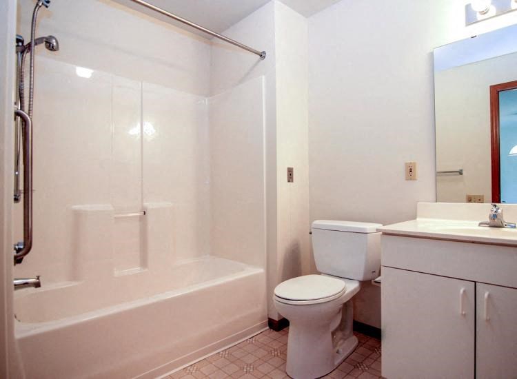 a bathroom with a toilet and a tub and a sink