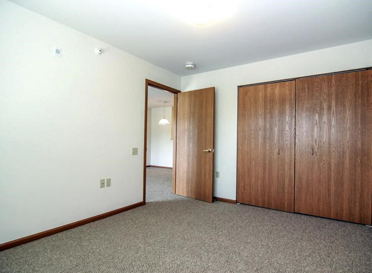 an empty room with two doors and a door to a hallway