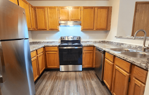 a kitchen with wood cabinets and stainless steel appliances
